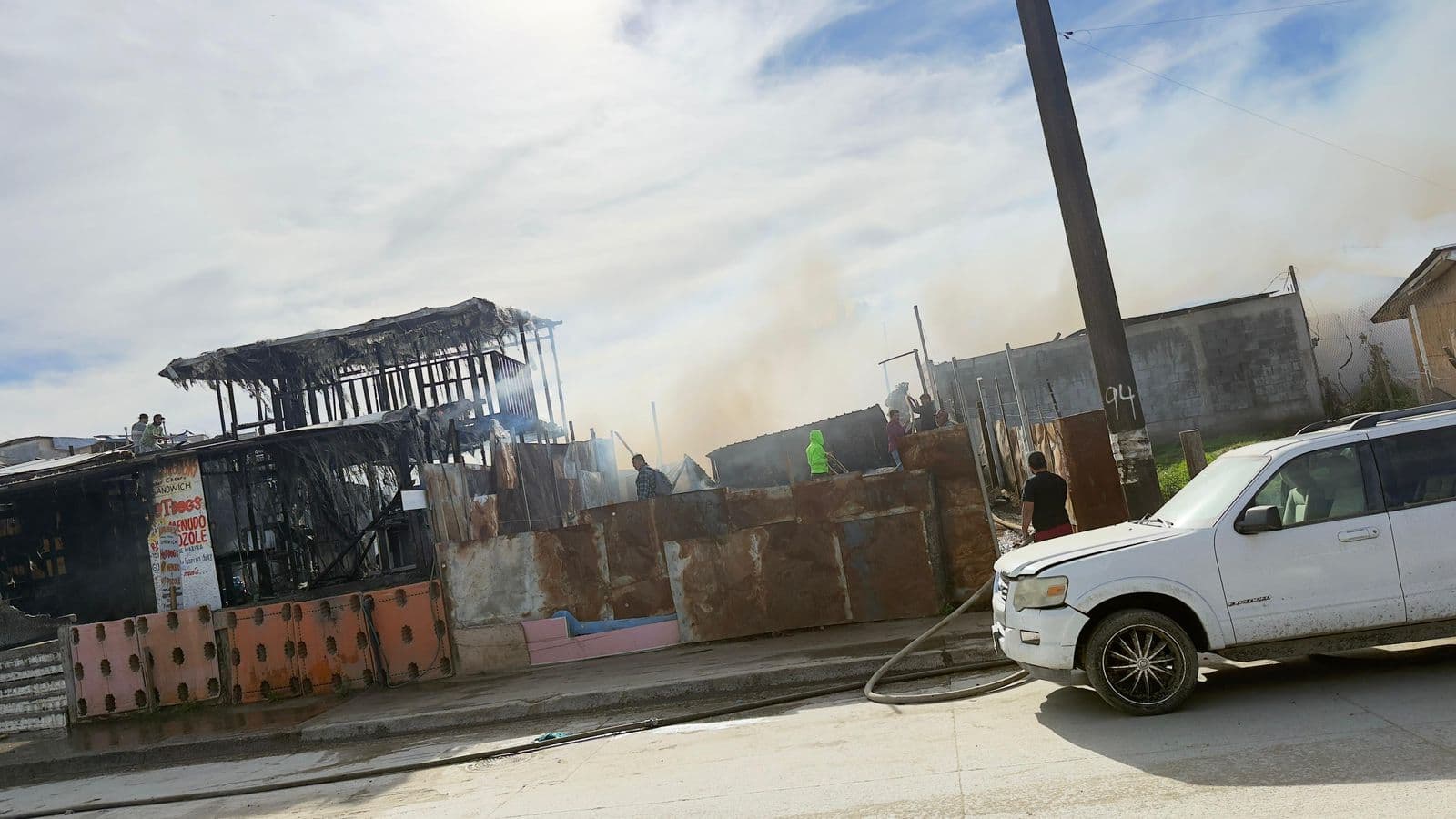 Elementos del Cuerpo de Bomberos de Tijuana durante las labores de contención del incendio en viviendas de la colonia Villa del Campo.