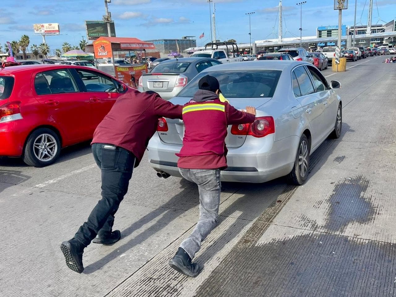 Personal de auxilio vial atiende a un conductor en la garita de San Ysidro como parte del programa de asistencia implementado por el Ayuntamiento de Tijuana