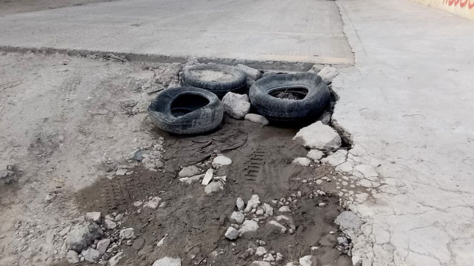 Vecinos del Maclovio Rojas tapan los baches con  llantas. I FOTO: Cortesía