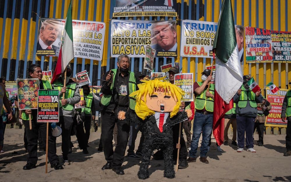 "Migrantes y activistas protestan en el muro fronterizo de Playas de Tijuana contra políticas migratorias de Trump."
