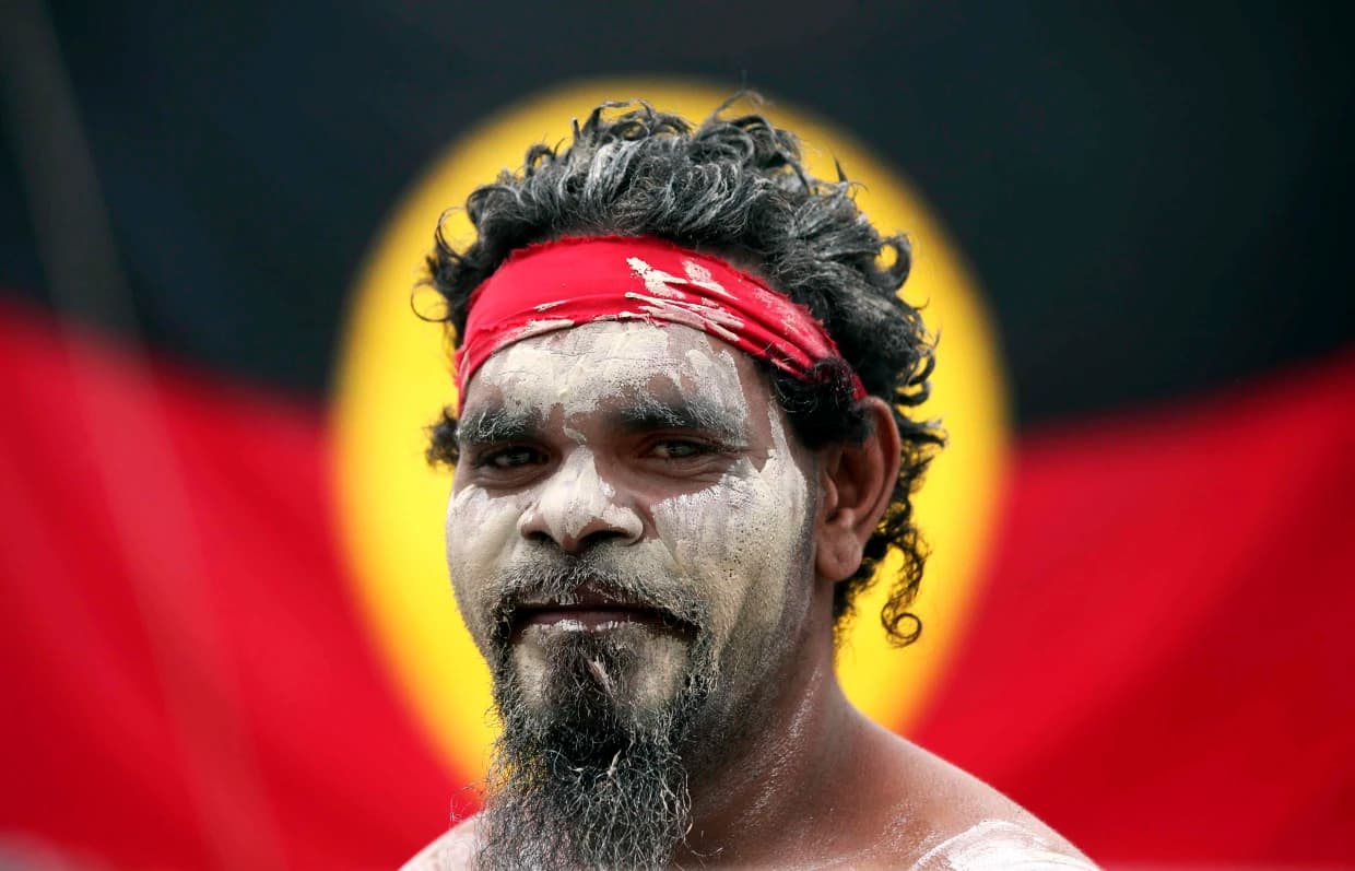 Aborigen australiano posando frente a la bandera nativa IFOTO: Rick Rycroft / AP file