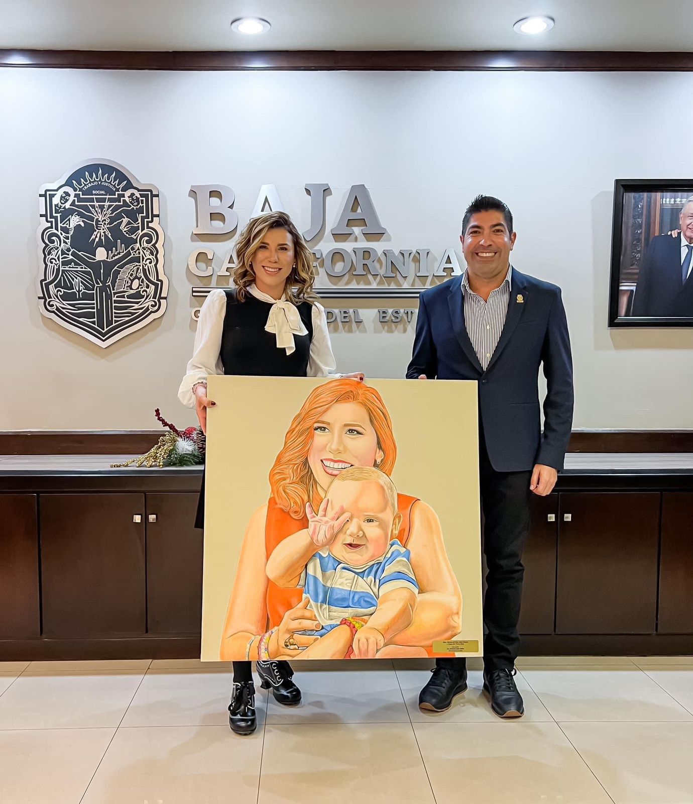 Presidente municipal de Ensenada, Armando Ayala Robles regalándole un retrato de la Gobernadora de Baja California, Marina del Pilar junto a su bebé
