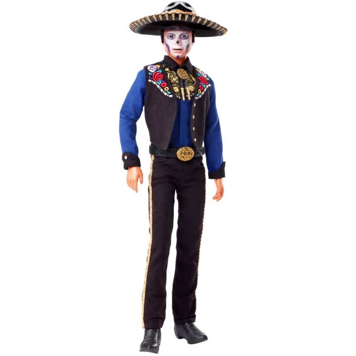 El atuendo charro de Ken presenta una camisa azul brillante debajo de un chaleco bordado, una corbata de bolero, pantalón con detalles en los costados y unas botas en color negro