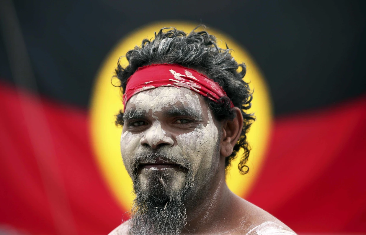 Aborigen australiano posando frente a la bandera nativa IFOTO: Rick Rycroft / AP file