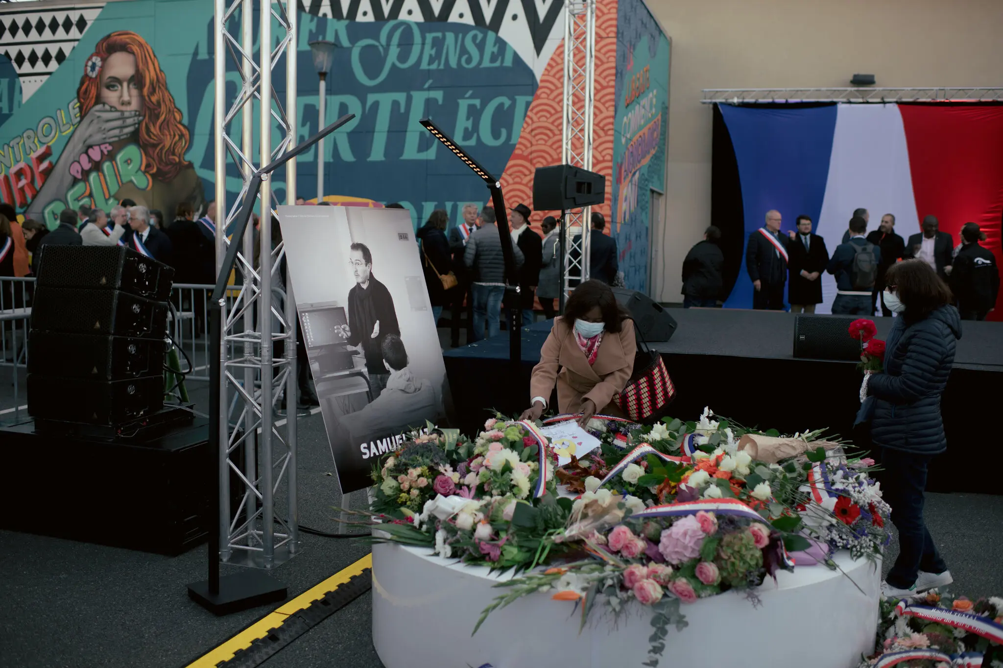 Personas colocando flores en 2021 cerca de la escuela donde el profesor asesinado, Samuel Paty, ejercía su oficio IFOTO: Dmitry Kostyukov/The New York Times