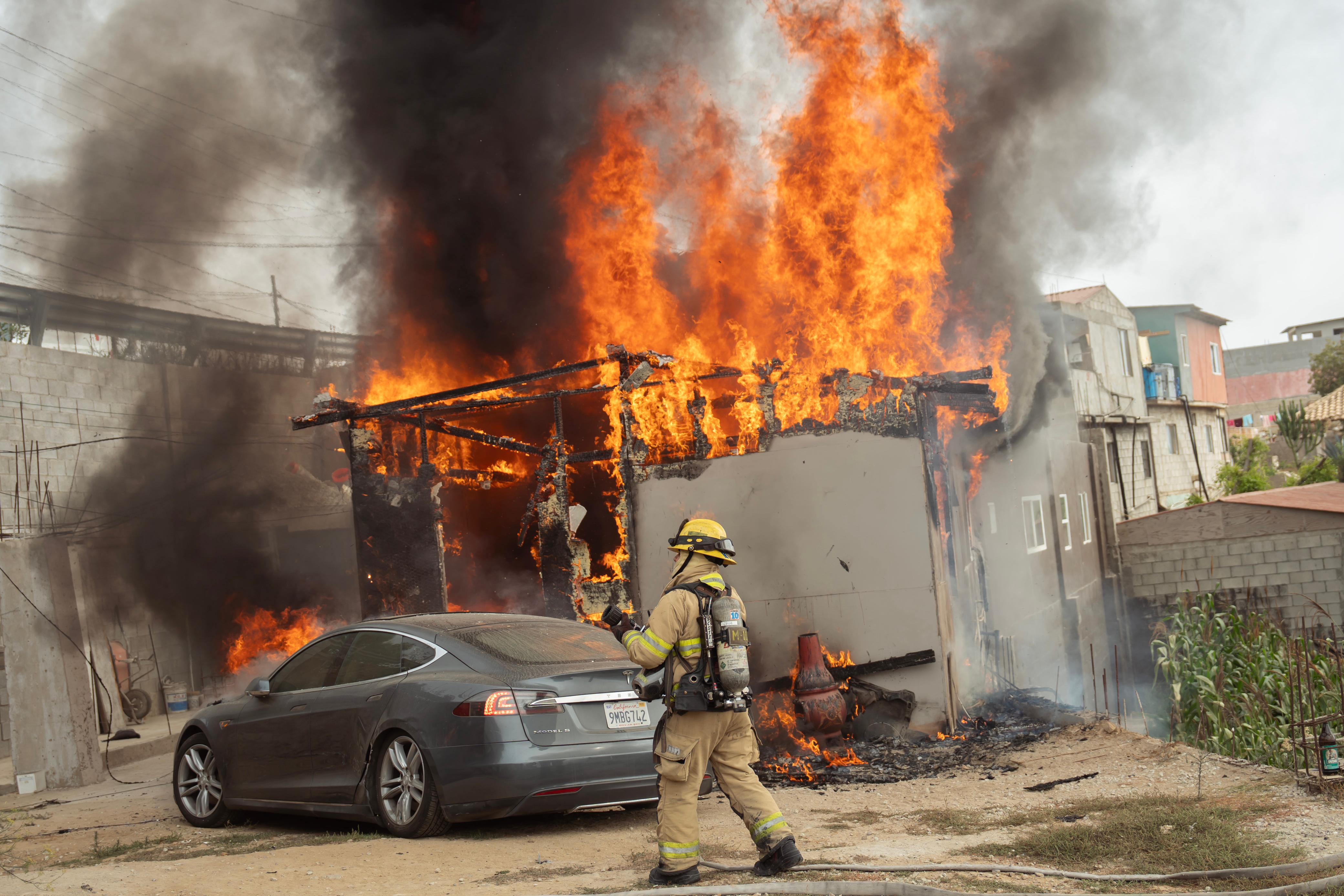 [VIDEO] Tesla connected to light pole catches fire, spreads to house