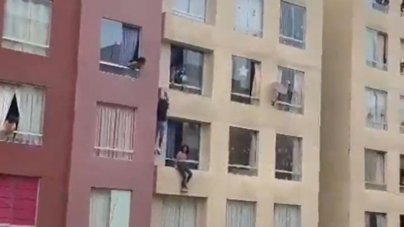 [VIDEO SENSBLE] Intenta hombre salvar a una chica de aventarse y cae de un edificio