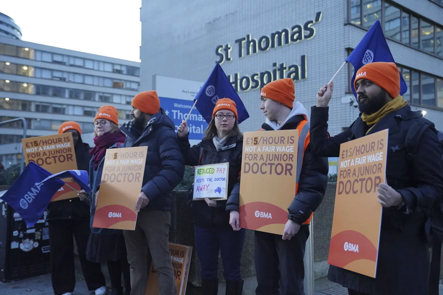 Doctores novatos de Reino Unido sosteniendo letreros que dicen "15 libras por hora no es un salario justo para un Doctor Jr" IFOTO: Web